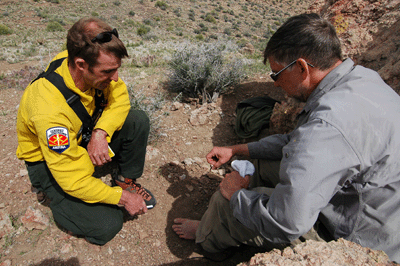 Brandon examining Dennis's injured foot